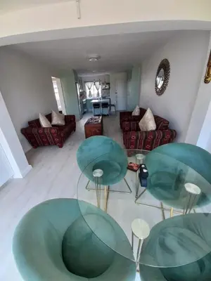 a living room with two green chairs and a couch at Whale Rock Estate Four 1 in Hermanus
