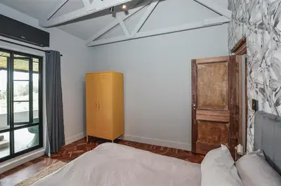 a bedroom with a bed and a yellow cabinet at 4 Bedroom Farm House in Brackenfell