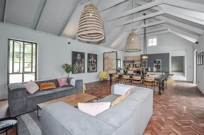 a living room with two couches and a kitchen at 4 Bedroom Farm House in Brackenfell