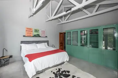 a bedroom with a large bed and green cabinets at 4 Bedroom Farm House in Brackenfell