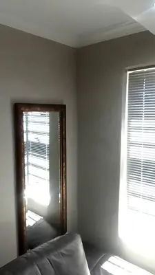 a mirror in the corner of a room with a window at Sisonke Guest House in Cape Town