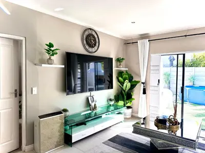 a living room with a glass table and a tv at Luxury 2bedrooms house in Cape Town