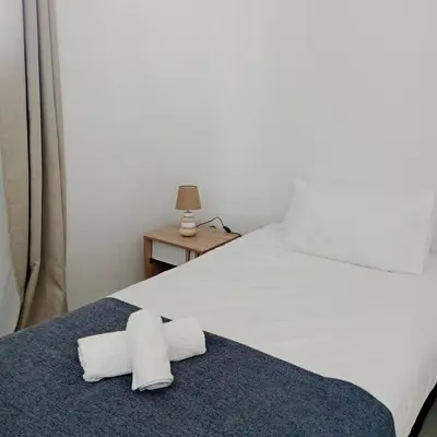 a bedroom with a bed with two towels on it at The Cozy Nest in Cape Town