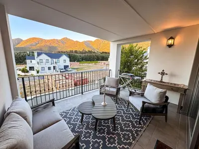 a living room with a couch and chairs on a balcony at Le Bourgette 28 Misty Wink in Franschhoek