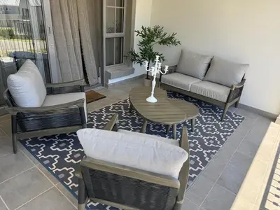 a living room with a couch and a table and chairs at Le Bourgette 28 Misty Wink in Franschhoek