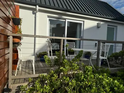 a porch with two chairs and a table at Otter Cottage in Pringle Bay in Pringle Bay