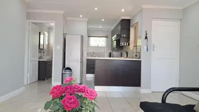 a kitchen with pink flowers in the middle at Gordon's bay - Sea view apartment in Cape Town