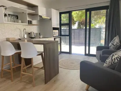 a kitchen and living room with a table and chairs at Zonnekus Guesthouse in Cape Town