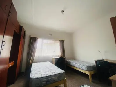 a small room with two beds and a window at Eliot TM in Cape Town