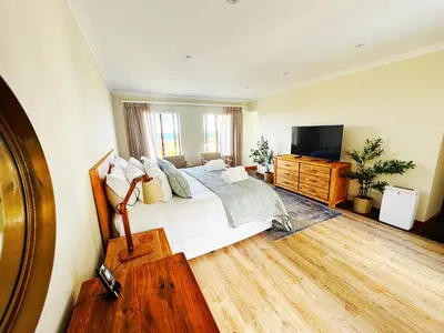 a bedroom with a bed and a television in it at Sea 'n Summit Hermanus in Hermanus