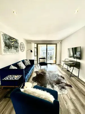 a living room with a blue couch and a table at Le Bourgette - Close to Town With Great Views in Franschhoek