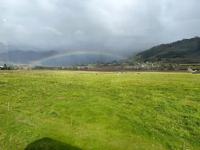 a rainbow in a field with a green field at Le Bourgette - Close to Town With Great Views in Franschhoek