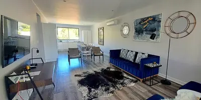 a living room with a blue couch and a table at Le Bourgette - Close to Town With Great Views in Franschhoek