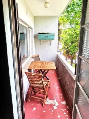a balcony with a table and chairs and a piano at Sunny Mountain View in Stellenbosch