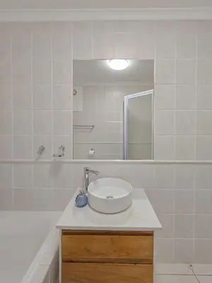 a white bathroom with a sink and a mirror at Spacious 3Bed 2bath sleep 8 Beachfront Apartment with Table Mountain and Ocean view in Cape Town