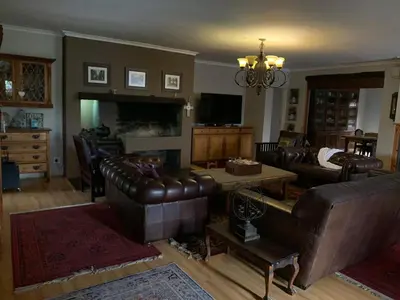 a living room with leather furniture and a chandelier at Johannies Home at Panorama Hospital in Cape Town