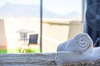 a towel sitting on top of a bed with a window at Villa Italia 933 by CTHA in Cape Town