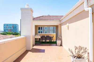 a balcony of a house with a table at Villa Italia 933 by CTHA in Cape Town