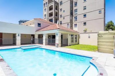 a large swimming pool in front of a building at Villa Italia 933 by CTHA in Cape Town