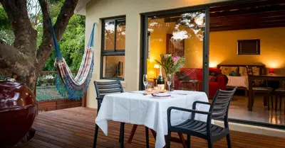 a dining room with a white table and chairs at TreeTop Apartment Cape Town in Cape Town