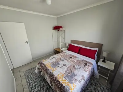 a bedroom with a large bed with red pillows at Watershed Self-Catering in Wolseley