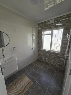 a bathroom with a shower and a sink and a window at Watershed Self-Catering in Wolseley