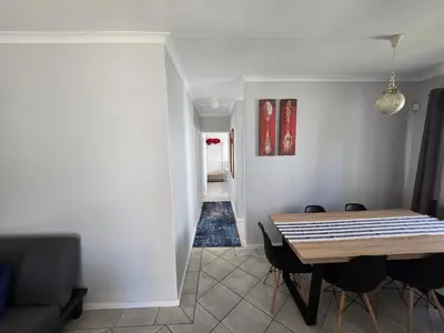 a dining room with a table and chairs and a hallway at Watershed Self-Catering in Wolseley