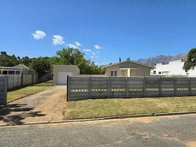a fence in front of a house at Watershed Self-Catering in Wolseley