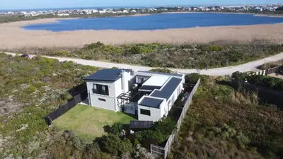an aerial view of a house on a hill next to the water at Two Lakes in Bettyʼs Bay