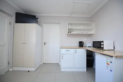a kitchen with white cabinets and a counter top at The Brookston Garden Cottage in Cape Town