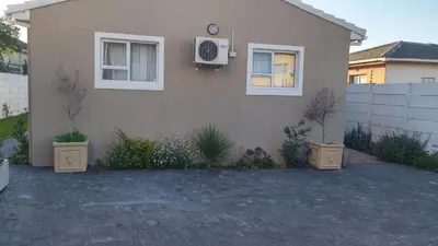 a house with a clock on the side of it at The Brookston Garden Cottage in Cape Town