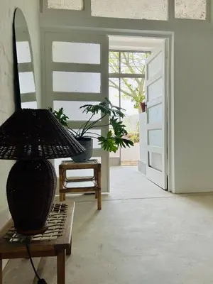 a room with a door and a chair with a potted plant at Stellenbosch Farm Studio Apartment in Penhill