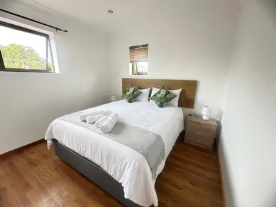 a bedroom with a large bed with two towels on it at MBCholidayhouse in Cape Town