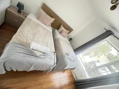 a bedroom with a bed with pillows and a window at MBCholidayhouse in Cape Town