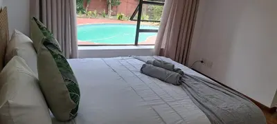 a bed in a bedroom with a view of a pool at MBCholidayhouse in Cape Town