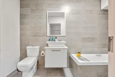 a bathroom with a white toilet and a sink at Waters Edge Luxury Apartment Century City in Cape Town