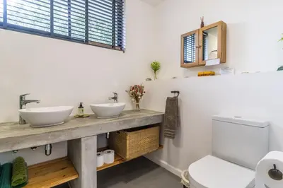 a bathroom with two sinks and a toilet at SeaScape Silversands in Bettyʼs Bay
