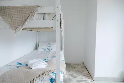 a bedroom with a bunk bed with towels on it at Vredekloof Views in Cape Town