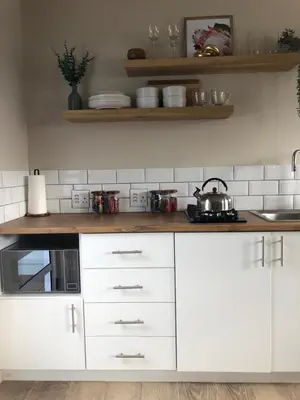 a kitchen with white cabinets and a stove top oven at Bettys Bay Breakaway in Bettyʼs Bay