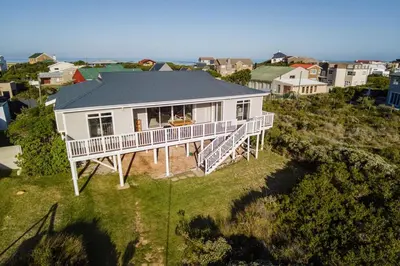 an aerial view of a white house on a hill at Tides in Bettyʼs Bay