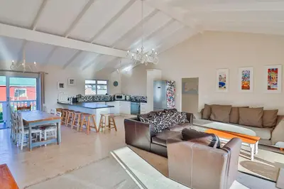 a living room with a couch and a table at Tides in Bettyʼs Bay