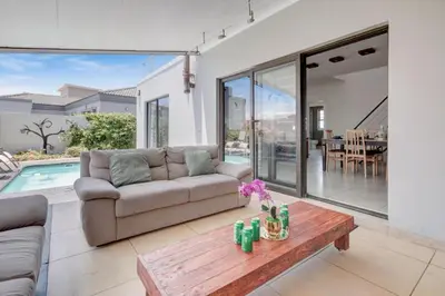 a living room with a couch and a table at Spacious Room with Balcony, Mountain Views, Modern Bathroom Tub and Shower and WiFi and Pool view in Cape Town
