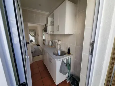 a small kitchen with a sink and a bathroom at Featherbed in Hermanus