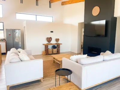 a living room with two white couches and a tv at 155 Hangklip self catering in Pringle Bay