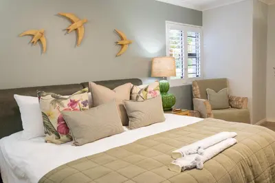 a bedroom with a large bed with towels on it at MOS- Palmiet in Kleinmond