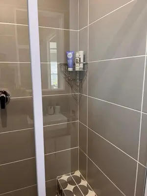 a bathroom with a shower with a glass door at Cozy Cottage in Cape Town