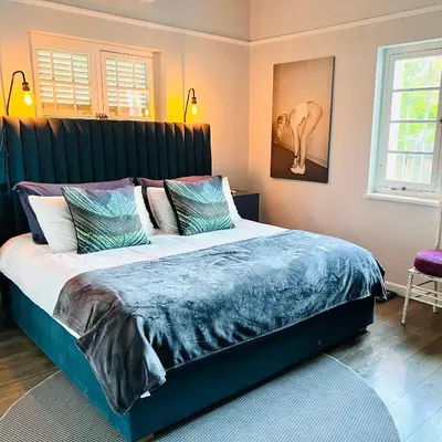 a bedroom with a large bed with a blue comforter at Spacious Stays Residence in Paarl