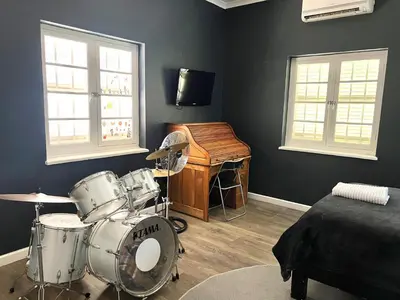 a room with a drum set and a piano at Spacious Stays Residence in Paarl