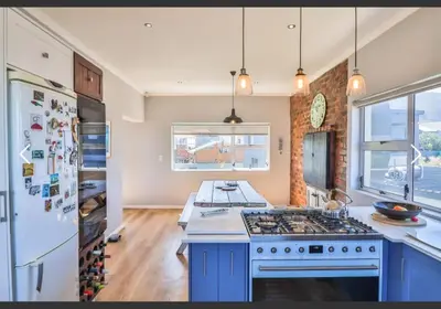 a kitchen with a stove and a refrigerator at OceansCrest Seaview Apartment in Bettyʼs Bay