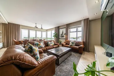 a living room with leather couches and a table at Apartment 206 Andringa Walk in Stellenbosch